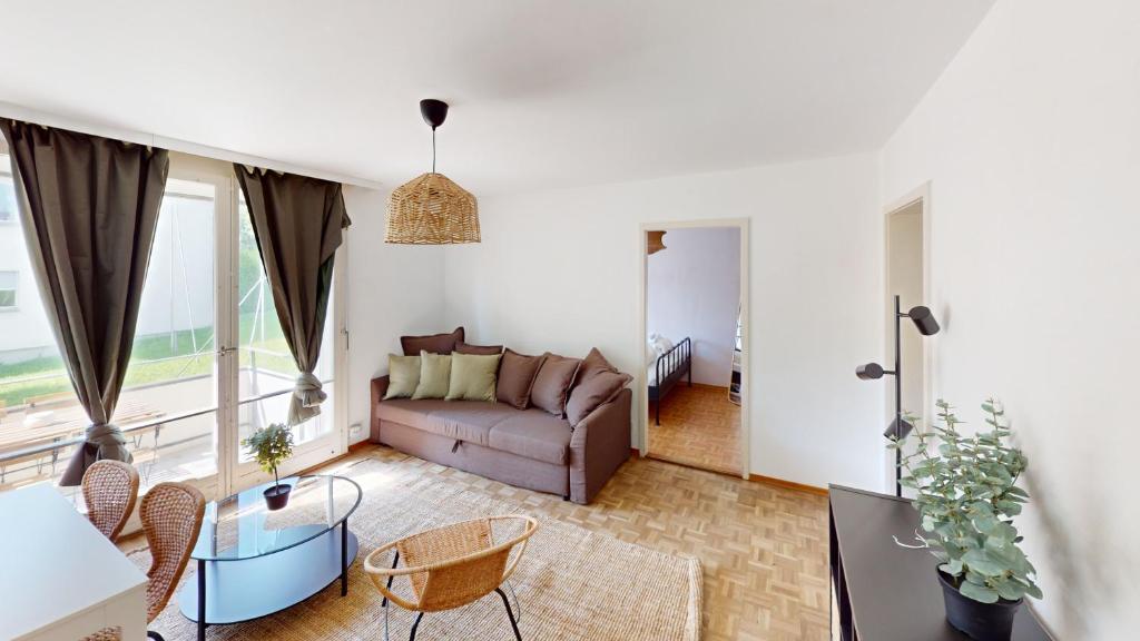 a living room with a couch and a table at Affordable Comfort 3BR Apartment in Zürich