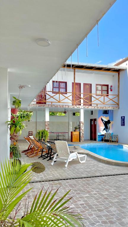 a building with a swimming pool and a patio at Hostal Laurita Beach in Montañita