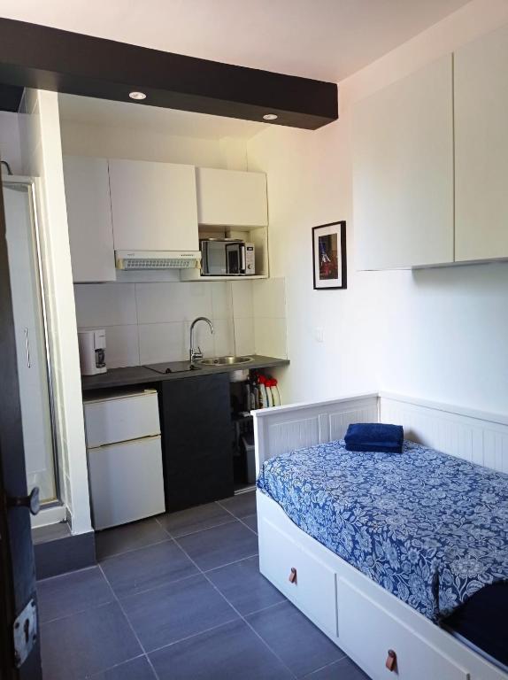 - une petite cuisine avec un lit dans une chambre dans l'établissement Studio proche de Paris, à Saint-Cloud