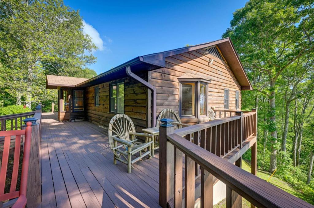 a log cabin with a deck and chairs on it at Yellow Mountain Vista Echoes at 4400 in Cullowhee