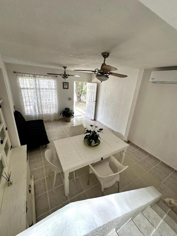 坎昆Bella casa centrica en Cancún para 6 personas的客厅配有桌子和吊扇