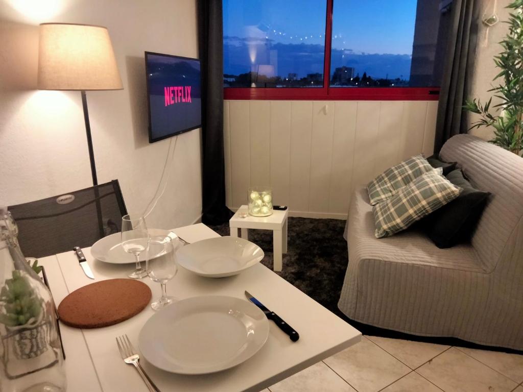 un salon avec une table et un canapé dans l'établissement Studio climatisé Avenue 83 à 10mn de Hyères et de Toulon, à La Valette-du-Var