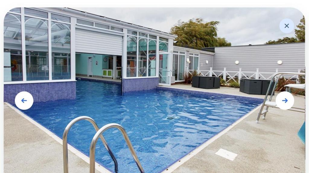 a swimming pool in front of a building at Luxury 2 bedroom Caravan Pets stay Free in Hunstanton
