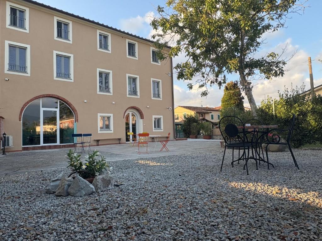 a building with a table and chairs in front of it at UGO Luxury Rooms in Lucca