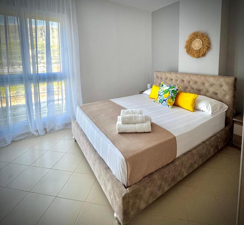 une chambre avec un grand lit avec des serviettes dessus dans l'établissement Endy Apartaments, à Orikum