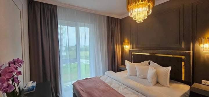 una camera da letto con un letto grande e una finestra di Exquisite Prima a Oradea