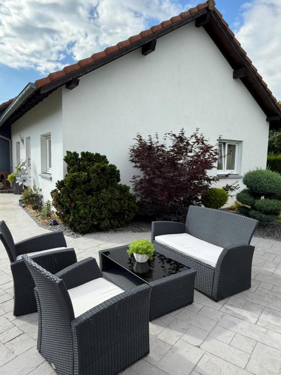 a patio with wicker chairs and a table at Au Jardin Secret in Rimsdorf