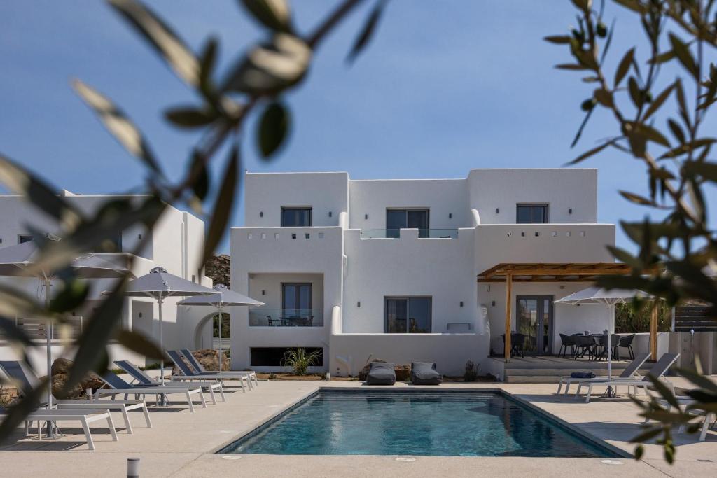 a villa with a swimming pool in front of a house at calmare collection hotel in Plaka