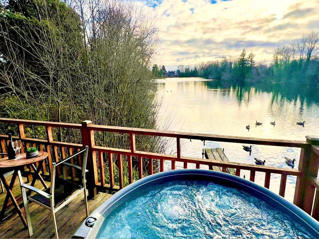 a hot tub on a deck with a view of a lake at Holly Lodge 12 Hot Tub in York