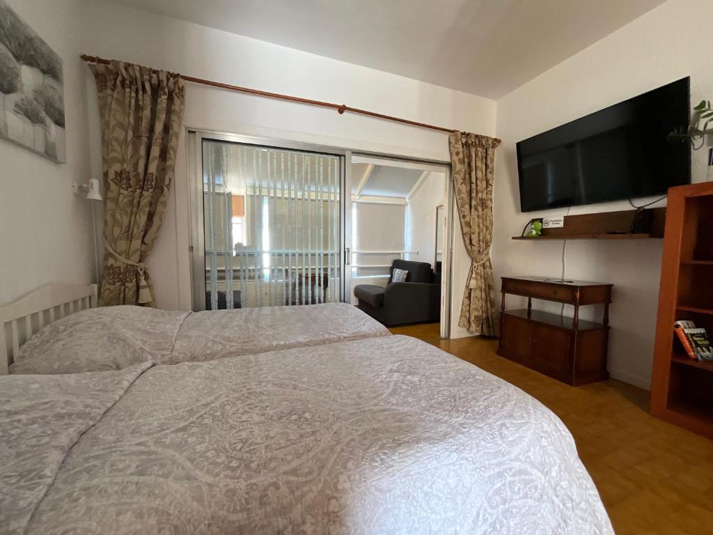 a bedroom with a bed and a flat screen tv at Trebol 1 in Costa Del Silencio