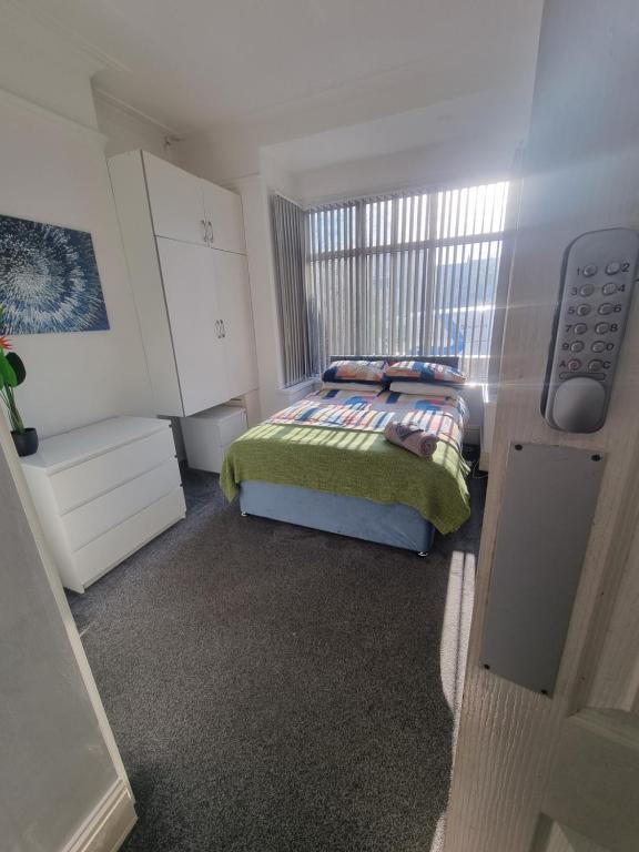 a small bedroom with a bed and a window at Generous double bedroom with ensuite - home from home! in Birmingham