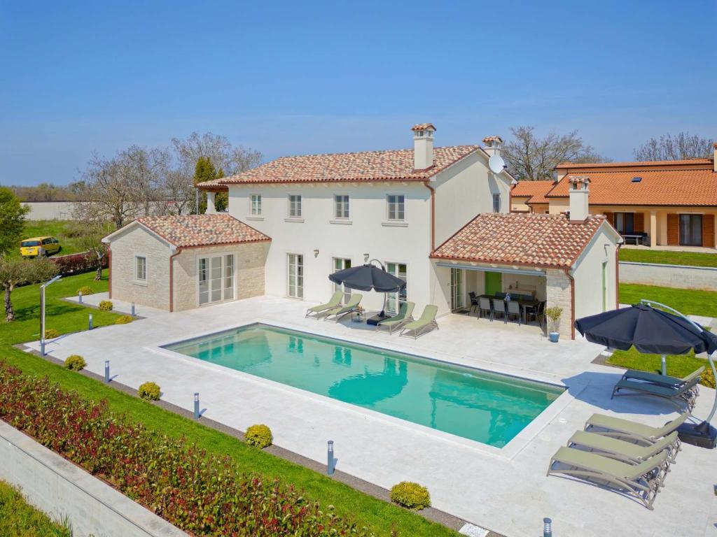 a large house with a swimming pool in the backyard at Villa Vego by Rent Istria in Muntrilj