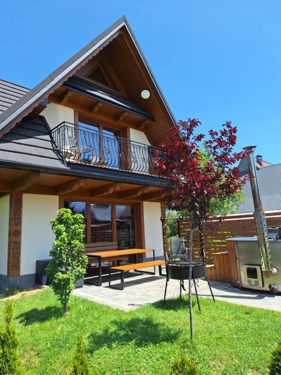 a house with a bench and a balcony at Domki Na Brzyzku in Zakopane