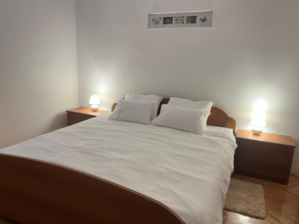 a bedroom with a large white bed with two night stands at Apartman Reizer - FREE PARKING in Samobor