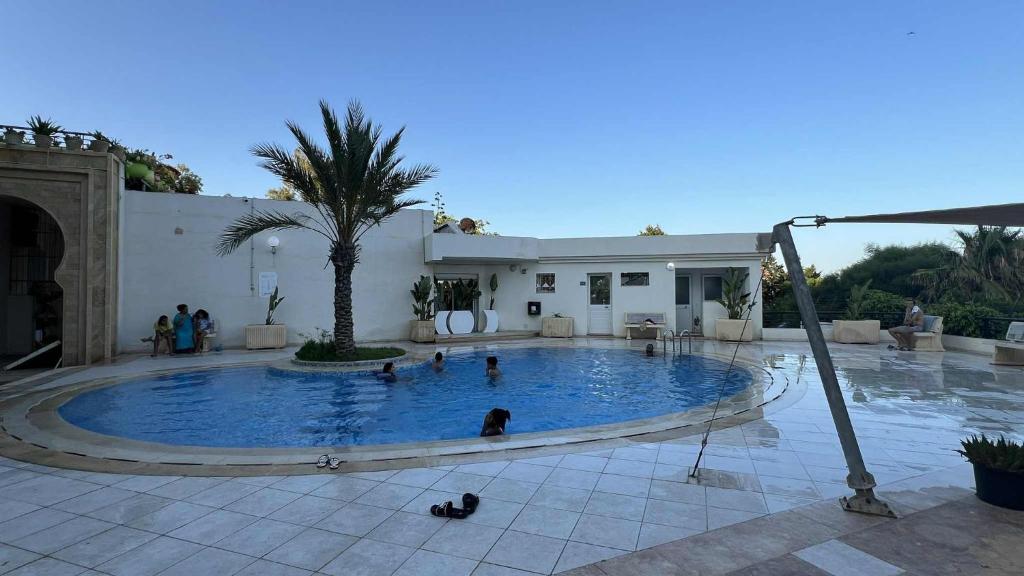 a group of people in a large swimming pool at Residence Golden Beach in Bin Rhilouf