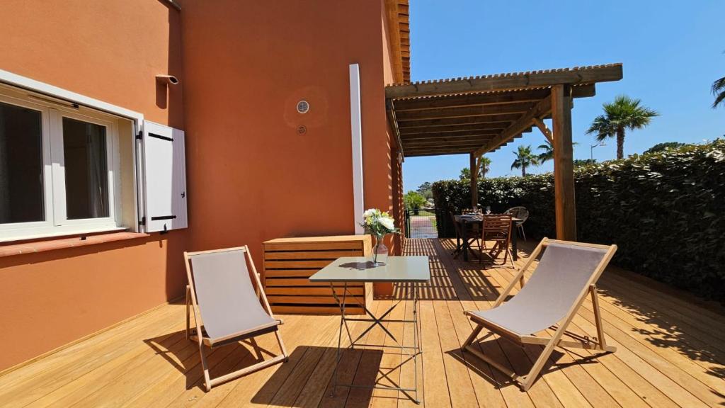 un patio con tavolo e sedie su un ponte di Casa Fadiju a Lecci