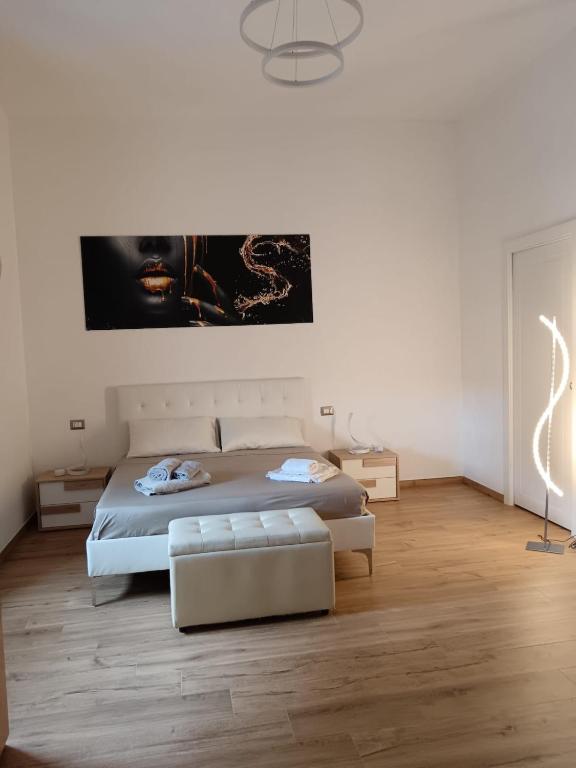 a white bedroom with a bed and a couch at Room private Ossi in Ossi