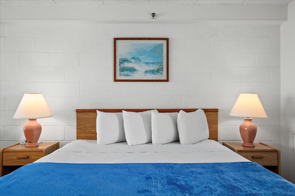 ein Schlafzimmer mit einem blauen und weißen Bett mit zwei Lampen in der Unterkunft Beachcomber Motel in Ocean City