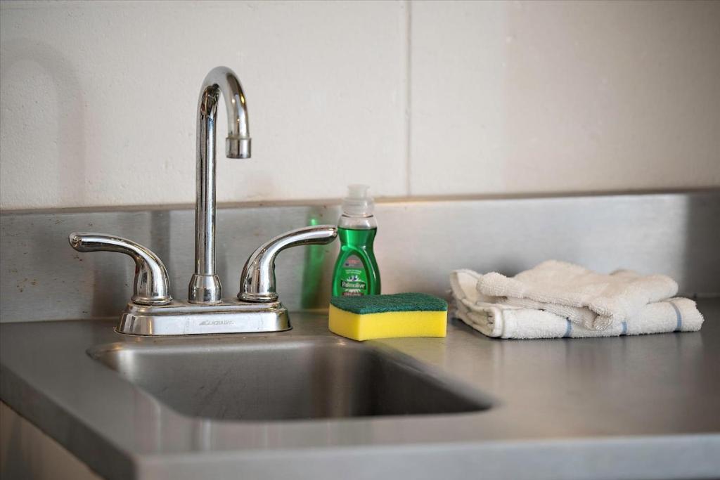 eine Küchenspüle mit einer grünen Flasche Seife und Handtüchern in der Unterkunft Beachcomber Motel in Ocean City
