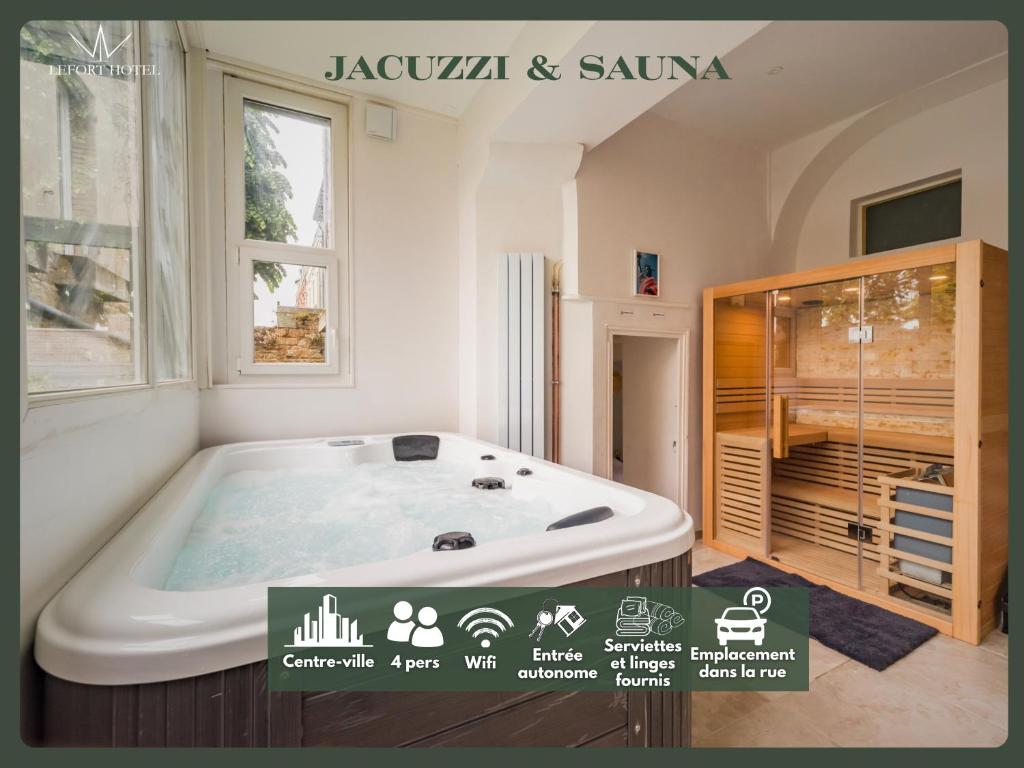 a jacuzzi tub in a room with a window at Hôtel Lefort - La suite impériale in Guingamp