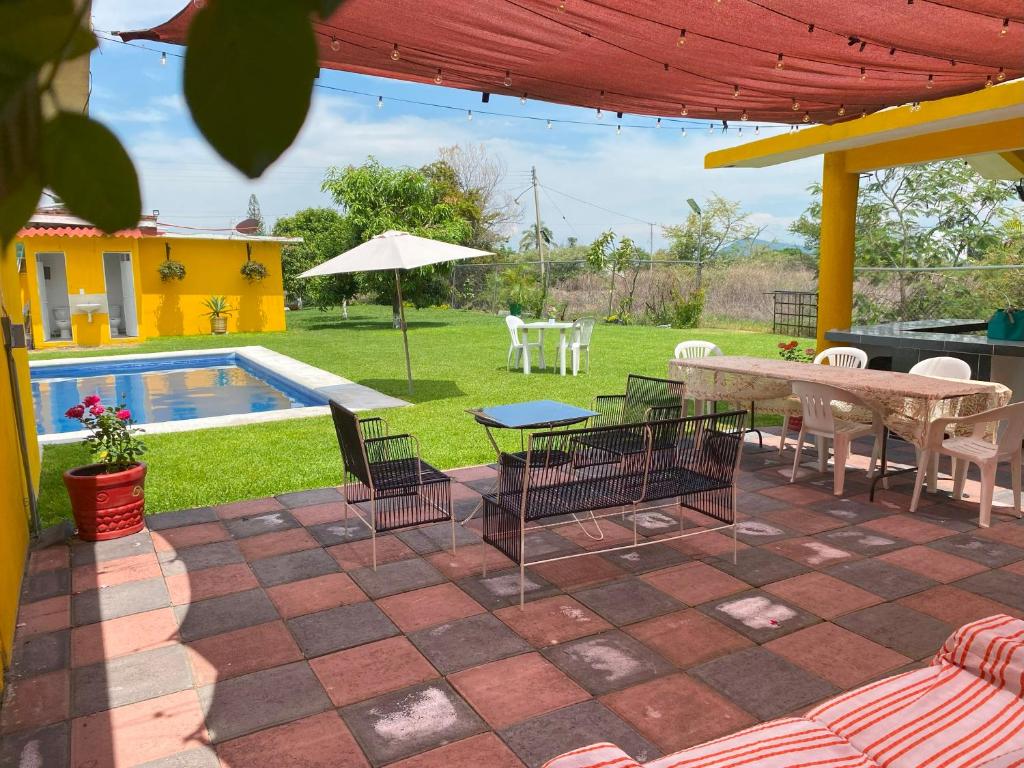 a patio with a table and chairs and a pool at "Casa San Miguel" Alberca privada, jardín, wifi, proyector,asador a 15 min de Cuautla en Morelos in Tlayecac