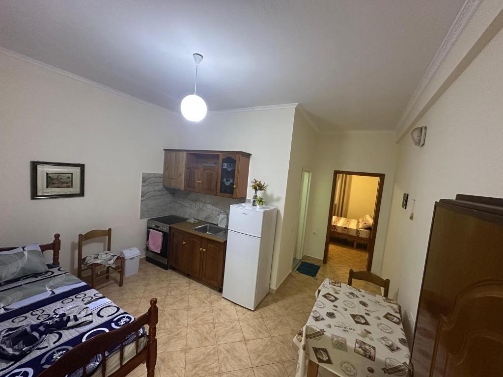 a room with a bed and a kitchen with a refrigerator at Dori 102 Apartment in Polisi i Vogël