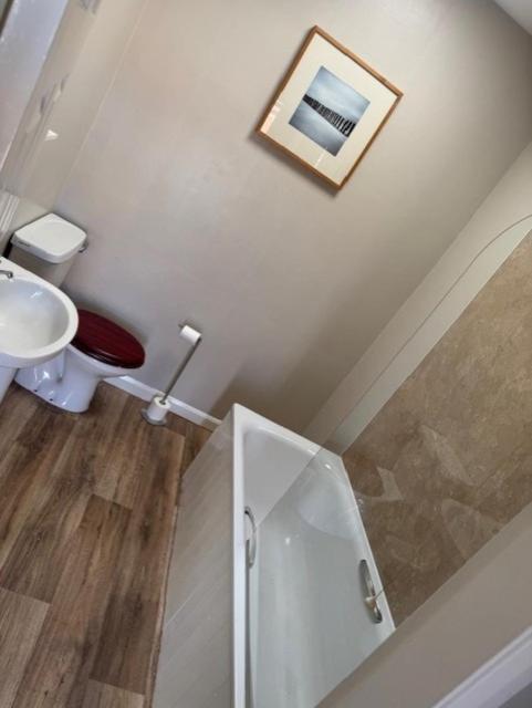 a white bathroom with a toilet and a sink at The Bell Hotel Cottages in Burgh le Marsh
