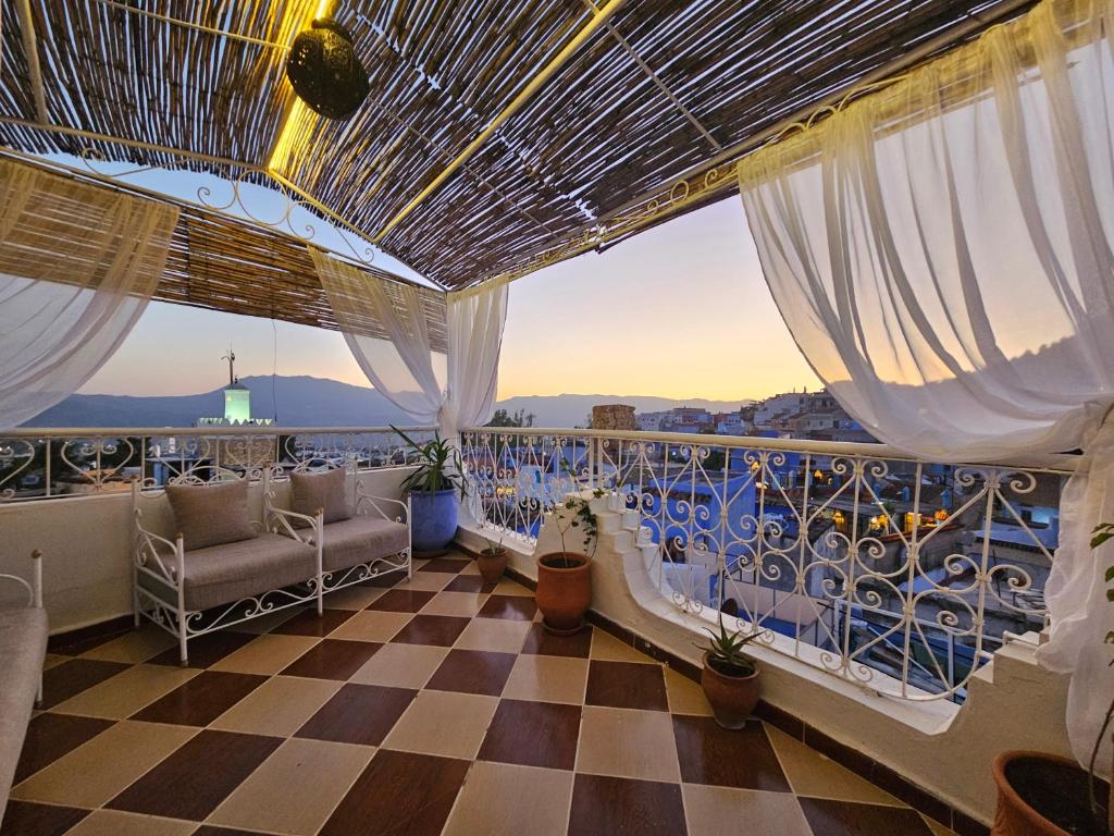 Un balcón con suelo de cuadros y vistas. en dar lalla chafia 1 studio triplex, en Chefchaouen