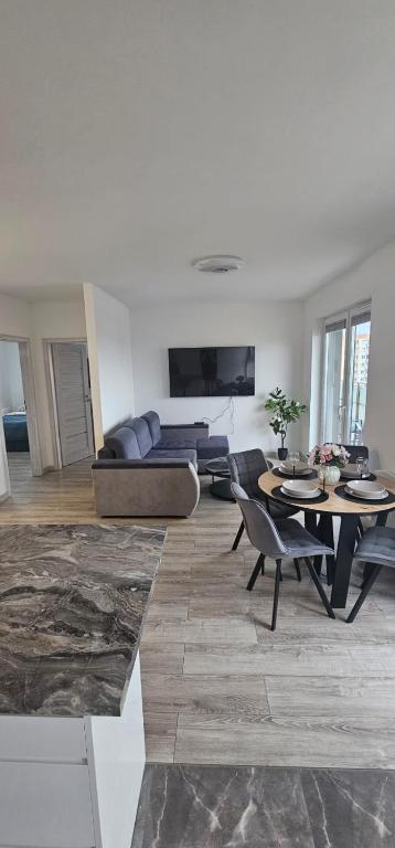 un soggiorno con un divano, un tavolo e delle sedie di APARTAMENT REGAL PARK 59 Elbląg a Elblag