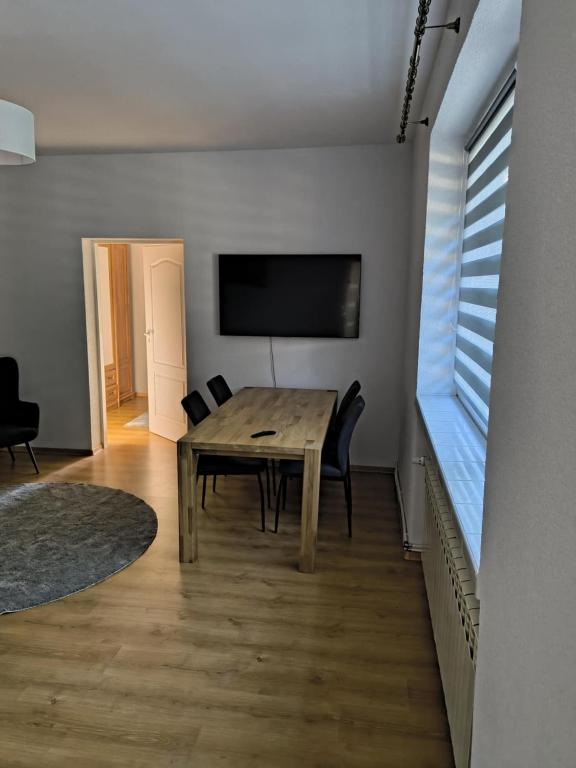 a dining room with a wooden table and a window at Nocleg pod Orzechem Apartament z 2 pokojami in Wapnica