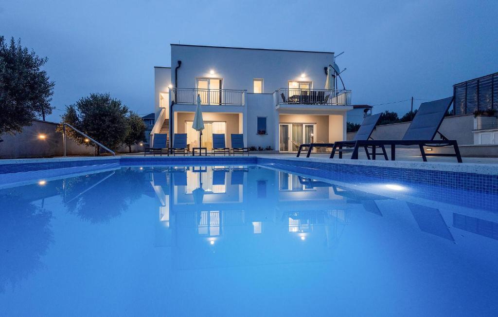a large swimming pool in front of a house at 4 Bedroom Gorgeous Home In Vrsi in Vrsi