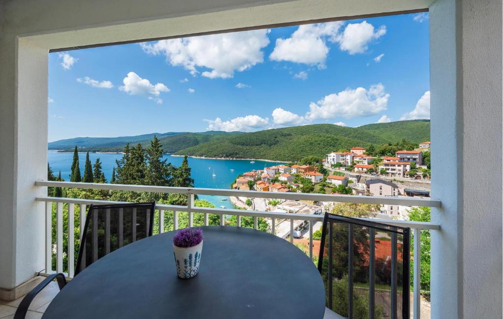a table on a balcony with a view of a city at 1 Bedroom Awesome Apartment In Rabac in Rabac