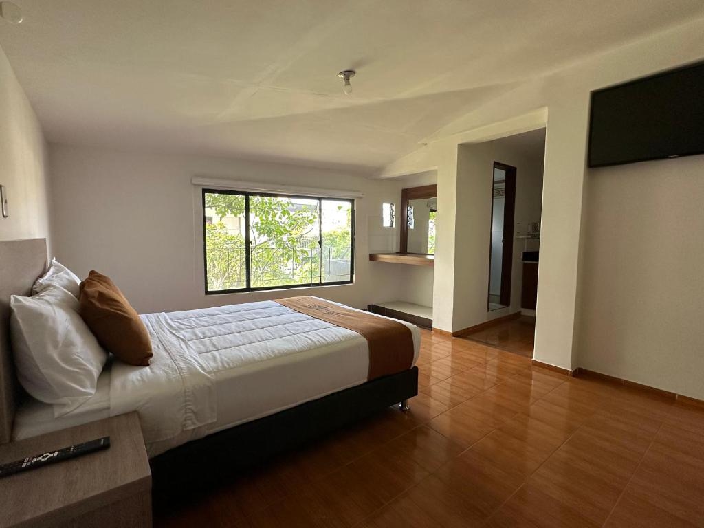 a bedroom with a large bed and a window at PERUGINO´S HOTEL GALERIA in Popayan