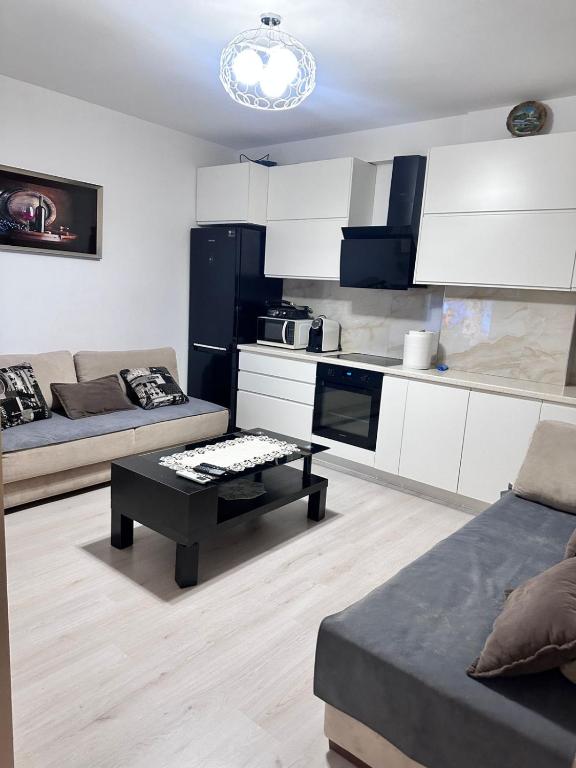 a living room with a couch and a table at Apartament Arena 2 in Elbasan