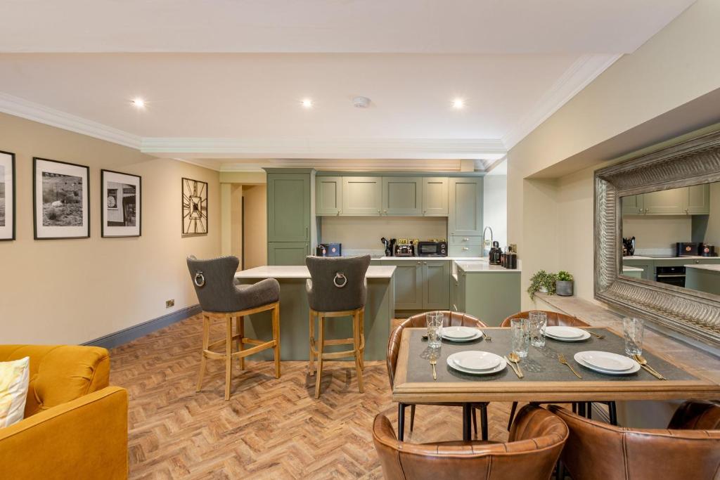 a living room with a table and chairs and a kitchen at The Library Suite in Marske