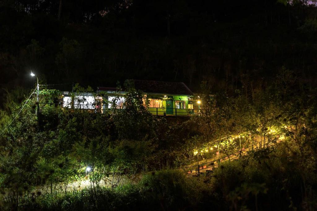 a building with lights on a hill at night at Ở Đây Thôi - Homestay Đà Lạt in Manline