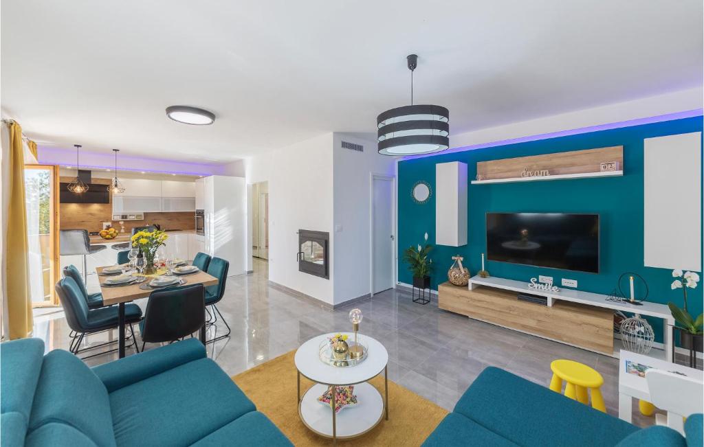 Una sala de estar con un sofá azul y una mesa. en 3 Bedroom Awesome Apartment In Kavran, en Kavran