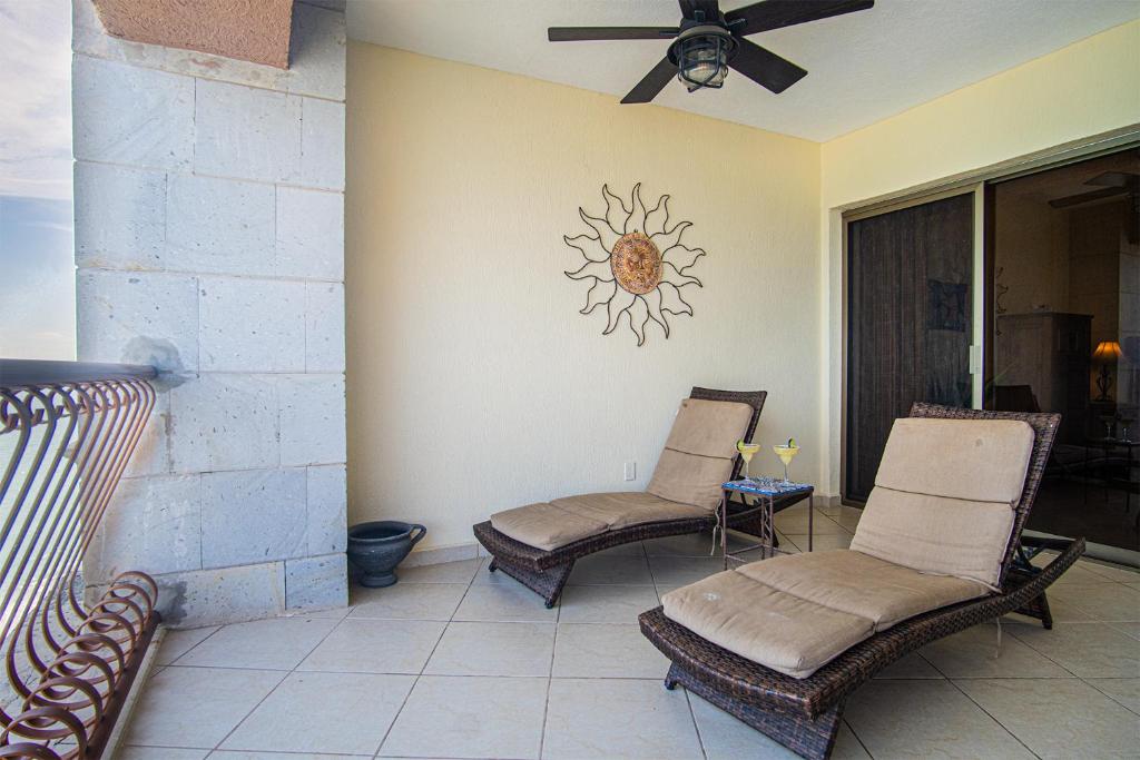 un patio con due sedie e un orologio solare sul muro di Sonoran Sun a Puerto Peñasco