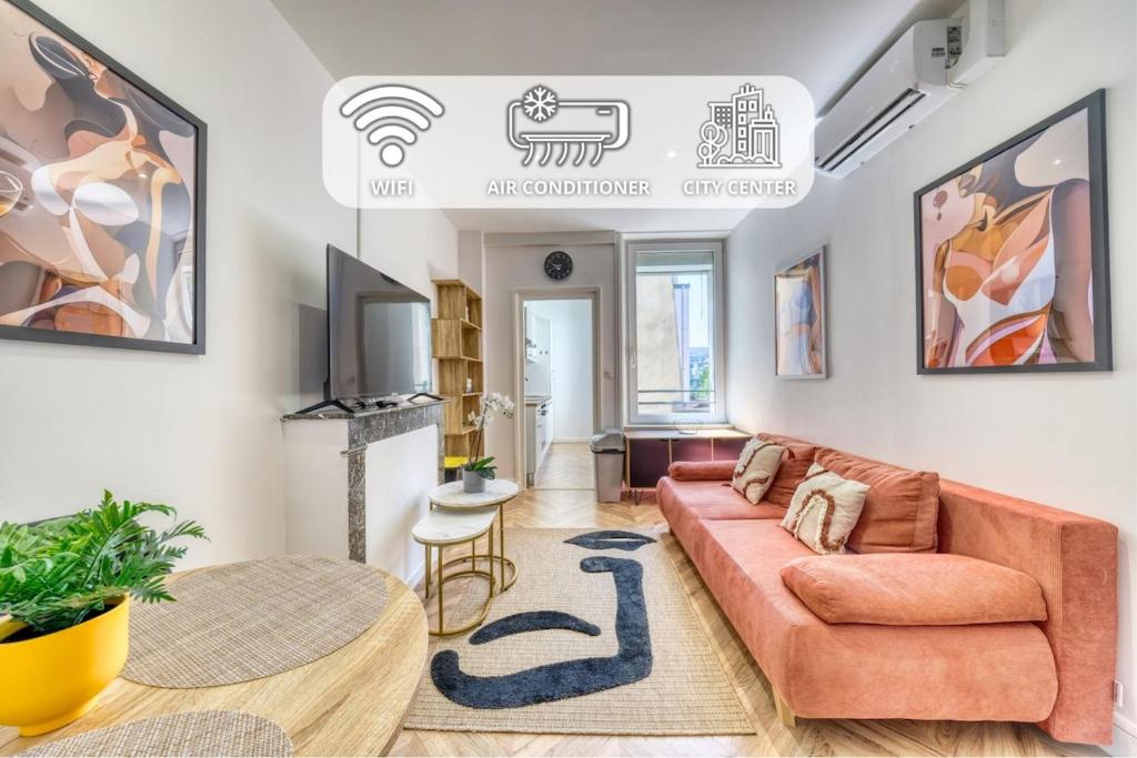 a living room with a couch and a table at La Résidence Courcelles - Climatisation in Reims