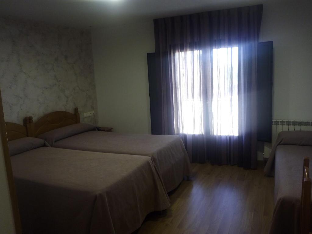 Postel nebo postele na pokoji v ubytování Hostal Plaza Mayor de Almazán
