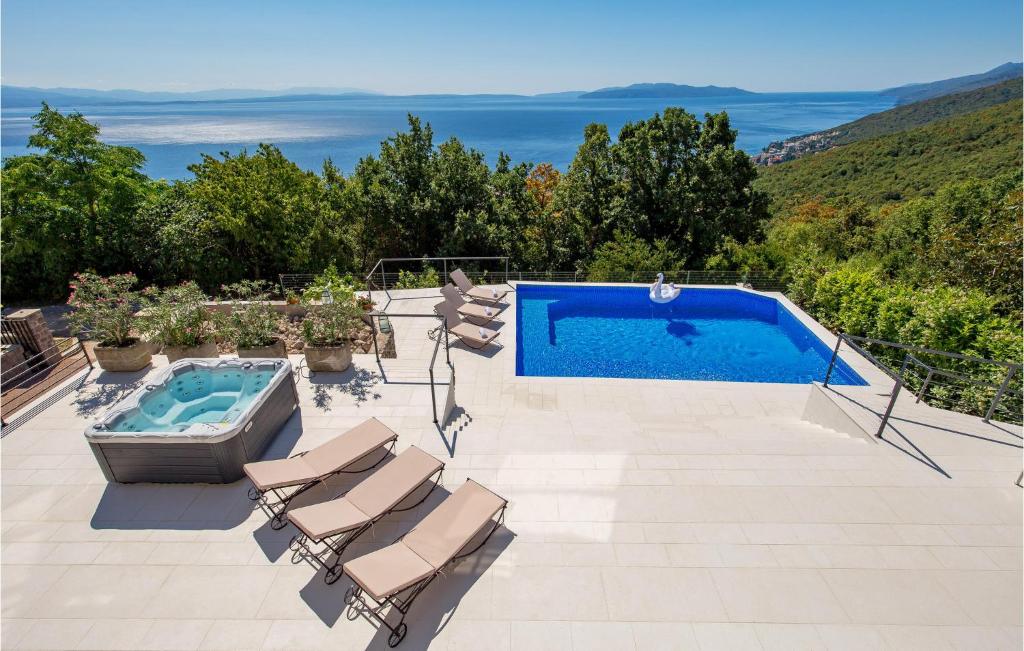 a swimming pool with lounge chairs and a swimming pool at Pet Friendly Home In Matulji With Sauna in Opatija