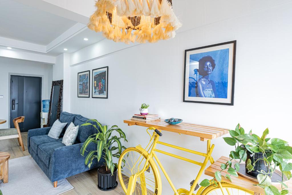 un salon avec un vélo jaune et un canapé dans l'établissement Marina Bay Apartment in Nairobi one & two Bedroom Westland's Off Rhapta Road with Swimming pool, gym & workspace - Zawi, à Nairobi