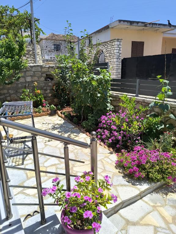 a patio with purple flowers and a chair on a balcony at The Darling Guesthouse in Himare