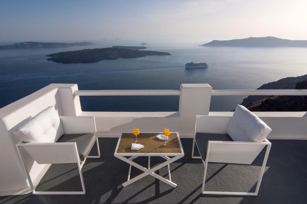 イメロヴィグリにあるWhite Rook Suite by Caldera Housesのテーブルと椅子、海の景色を望むバルコニー
