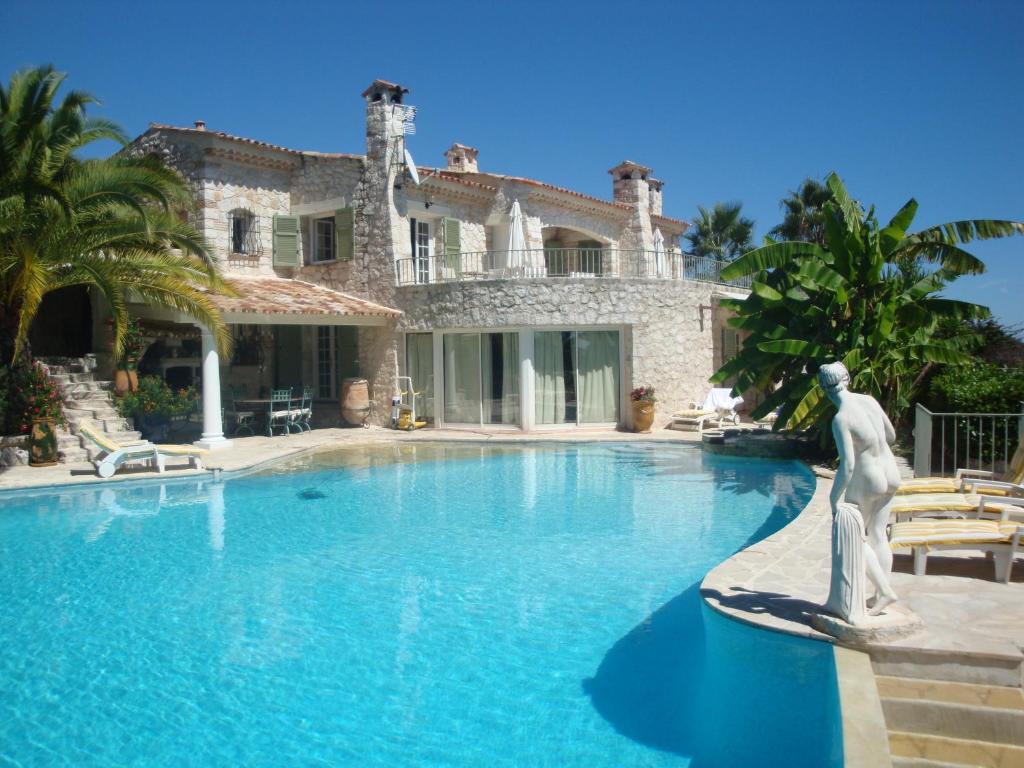 a large house with a statue in front of a swimming pool at La Bergerie B&B in Vence