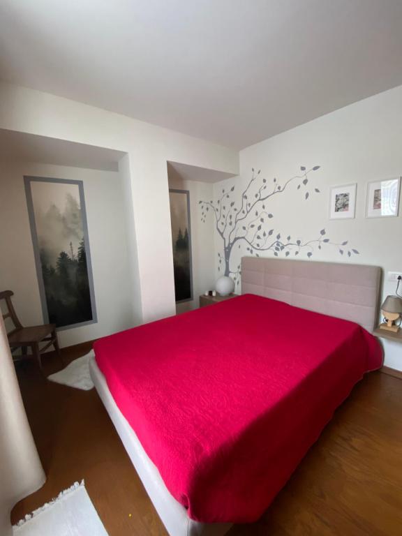 a bedroom with a bed with a red blanket at Maison Poluc - Maison Adeline in Champoluc