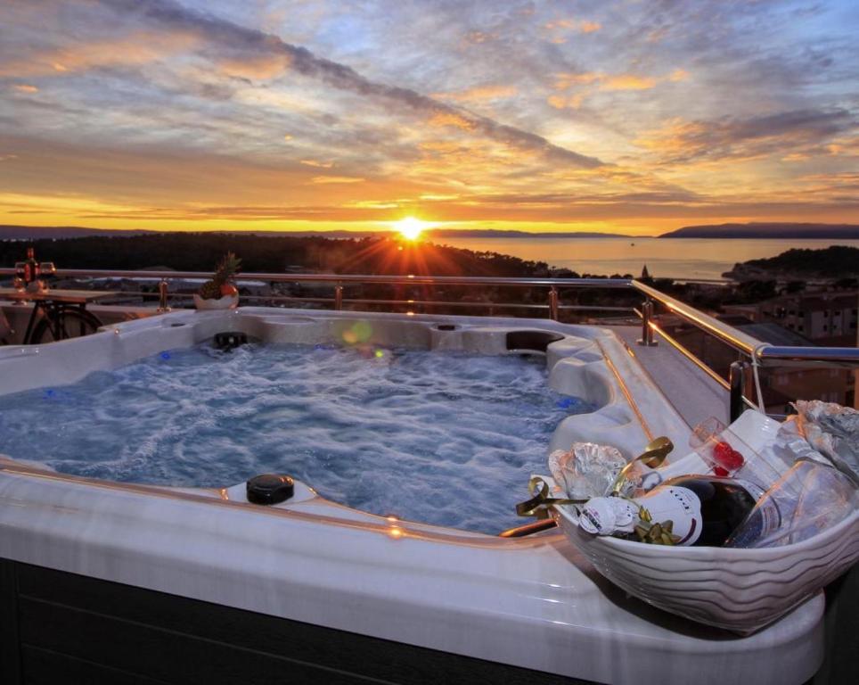 a hot tub on a cruise ship with the sunset at Luxury penthouse with jacuzzi, panoramic view in Makarska
