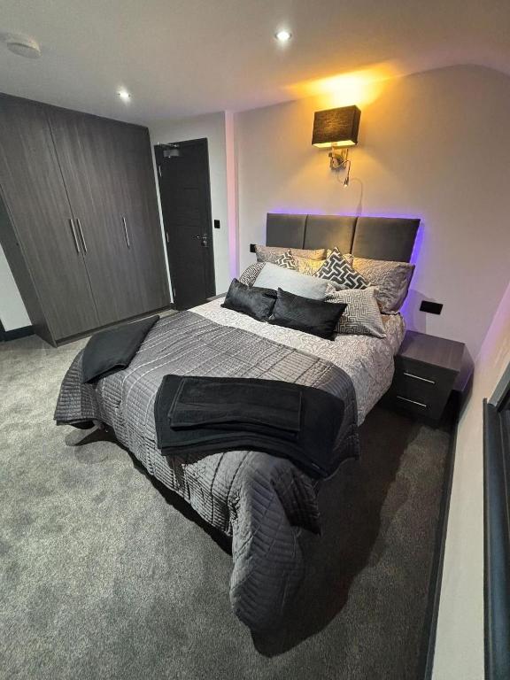 ein Schlafzimmer mit einem großen Bett mit violettem Licht in der Unterkunft Modern 3bed | 3en-suite | Garden in Reading