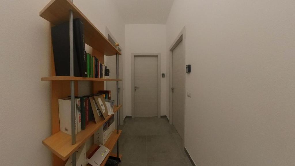 a hallway with a tv and book shelves at Charming SantAntioco Apt with 2-Way Air Con in SantʼAntìoco