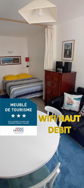 Cette chambre comprend 2 lits et une table avec un panneau. dans l'établissement La Goélette Beau duplex A 150 m du centre ville et 400m de la plage de l'écluse, à Dinard
